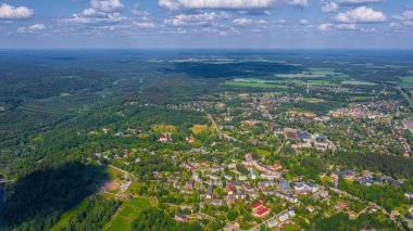 Güneşli bir yaz gününde Sigulda üzerinde uçan dron 'dan gelen güzel panoramik hava manzaralı fotoğraf ormanların ve kırsal alanların arka planına karşı. Sigulda, Letonya (dizi)