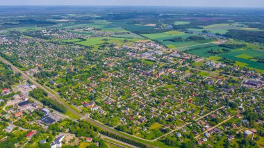 Güneşli bir yaz gününde Sigulda üzerinde uçan dron 'dan gelen güzel panoramik hava manzaralı fotoğraf ormanların ve kırsal alanların arka planına karşı. Sigulda, Letonya (dizi)