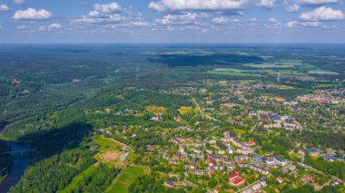 Güneşli bir yaz gününde Sigulda üzerinde uçan dron 'dan gelen güzel panoramik hava manzaralı fotoğraf ormanların ve kırsal alanların arka planına karşı. Sigulda, Letonya (dizi)