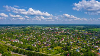 Güneşli bir yaz gününde Sigulda üzerinde uçan dron 'dan gelen güzel panoramik hava manzaralı fotoğraf ormanların ve kırsal alanların arka planına karşı. Sigulda, Letonya (dizi)