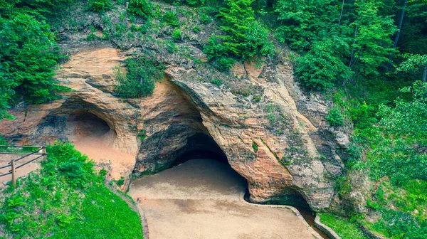 Gutmanala antik tarikat sahasındaki insansız hava aracı görüntüsü ve koruma altındaki jeolojik özellikler: duvarlarında yazıtlar bulunan kumtaşı mağarası, Gauja Ulusal Parkı, Sigulda, Letonya (seriler))