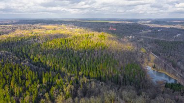 Güneşli bir kış gününde Sigulda üzerinde uçan İHA 'dan gelen güzel panoramik hava manzaralı fotoğraf ormanların ve kırsal alanların arka planında karsız. Sigulda, Letonya (dizi)