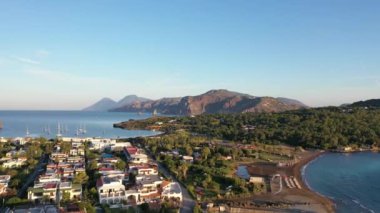 Porto di Ponente, Vulcano, Lipari ve Salina Aeolian Adaları Tyrhenian Denizi, Sicilya, İtalya 'da yatları olan siyah kumlu plajın güzel panoramik 4K videosu.