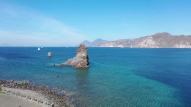 Porto di Ponente, Vulcano, Lipari ve Salina Aeolian Adaları Tyrhenian Denizi, Sicilya, İtalya 'da yatları olan siyah kumlu plajın güzel panoramik 4K videosu.