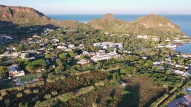 Porto di Ponente, Vulcano, Lipari ve Salina Aeolian Adaları Tyrhenian Denizi, Sicilya, İtalya 'da yatları olan siyah kumlu plajın güzel panoramik 4K videosu.