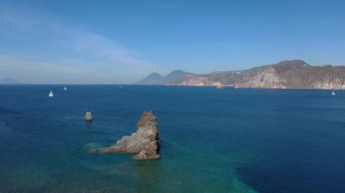Porto di Ponente, Vulcano, Lipari ve Salina Aeolian Adaları Tyrhenian Denizi, Sicilya, İtalya 'da yatları olan siyah kumlu plajın güzel panoramik 4K videosu.