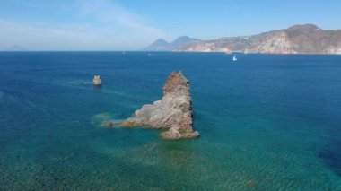 Porto di Ponente, Vulcano, Lipari ve Salina Aeolian Adaları Tyrhenian Denizi, Sicilya, İtalya 'da yatları olan siyah kumlu plajın güzel panoramik 4K videosu.