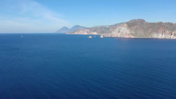 Belle vidéo aérienne panoramique 4K de drone volant de la plage de sable noir avec des yachts dans un petit havre de paix à Porto di Ponente, à Vulcano, Lipari et Salina Iles Eoliennes Mer Tyrrhénienne, Sicile, Italie 