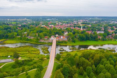 Uçan drondan Venta Rapid şelalesine, Avrupa 'nın en geniş şelalesine ve bir yaz günü Kuldiga, Letonya' da Avrupa 'nın en uzun üçüncü tuğla köprüsüne kadar uzanan güzel panoramik hava manzaralı fotoğraf. (seri)