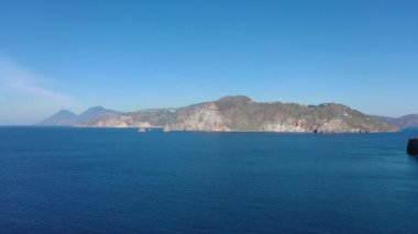 Vulcano adasındaki kayalarda uçan dron ve parlak mavi Tyrhenian Denizi Aeolian Adaları, Sicilya, İtalya 'daki (dizi) 4K panoramik video)
