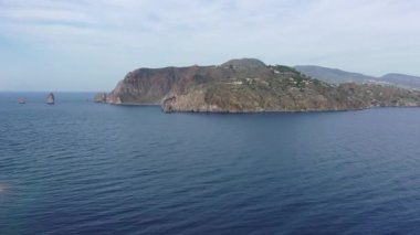 Vulcano adasındaki kayalarda uçan dron ve parlak mavi Tyrhenian Denizi Aeolian Adaları, Sicilya, İtalya 'daki (dizi) 4K panoramik video)