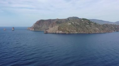 Vulcano adasındaki kayalarda uçan dron ve parlak mavi Tyrhenian Denizi Aeolian Adaları, Sicilya, İtalya 'daki (dizi) 4K panoramik video)