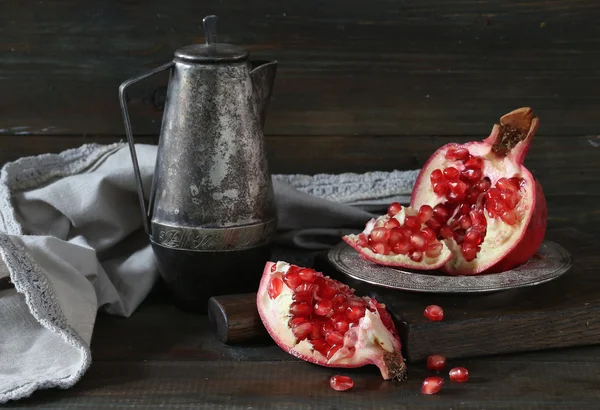 Pieces of ripe pomegranate on wooden table — Stock Photo, Image