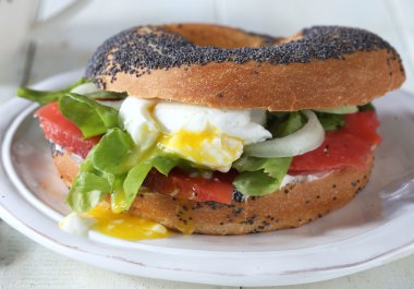 Somon balığı, yumurta ve krem peynir beyaz tabakta simit