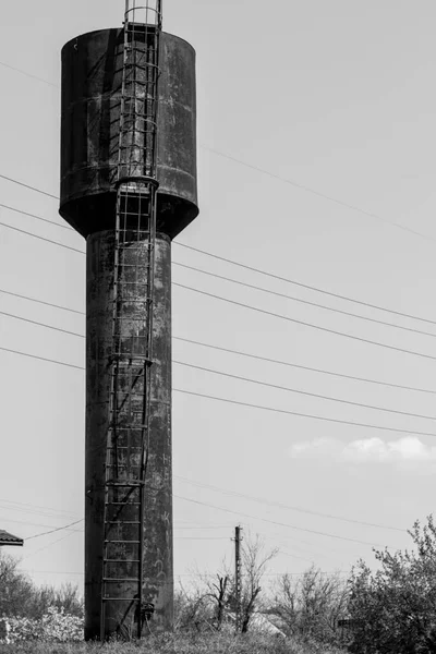 Güneşli bir günde yükselen bir su kulesinin siyah beyaz fotoğrafı