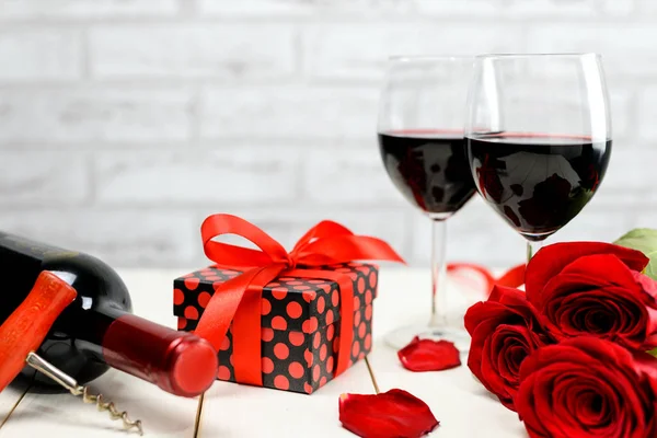 Una copa de vino, rosas y un regalo —  Fotos de Stock