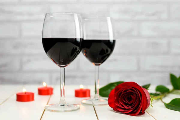 Una copa de vino, rosa y velas encendidas —  Fotos de Stock