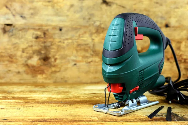 Elektrikli yapboz için eski ahşap arka planda metin için kopyalama alanı olan bir yapboz ve bıçaklar.