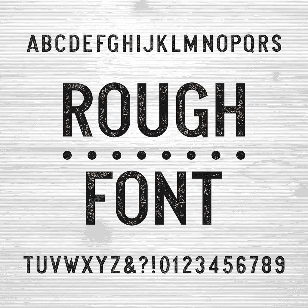 Rough alphabet font. Scratched type letters and numbers on a wooden background.