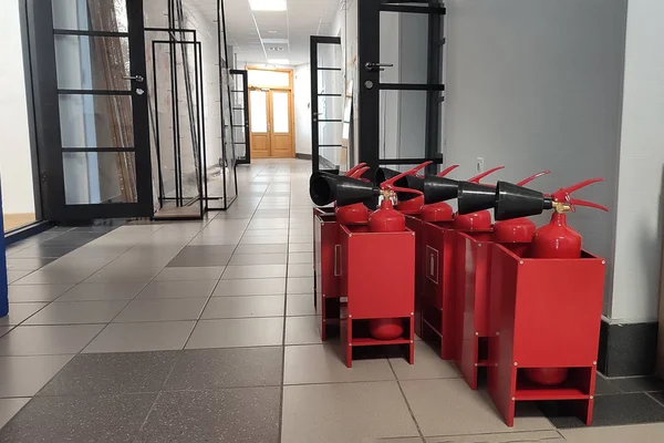 Fire extinguisher in workplace office. New Red tank of fire extinguisher in boxes