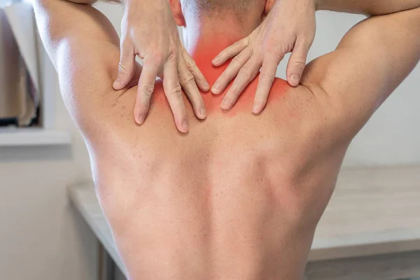 man rubs his hands with painful area in upper back. man suffering from neck and shoulder pain.