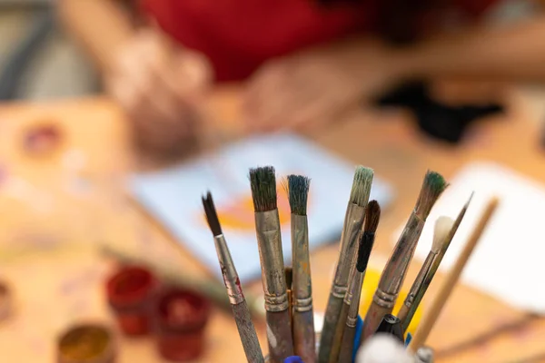 art school background, background of classes at art school, blurry woman drawing and painting