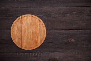 Yuvarlak ahşap kesme tahtası ahşap arka plan üzerinde