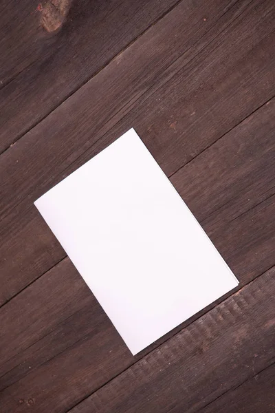 Sheet of paper folded in half on a wooden background — Stock Photo, Image