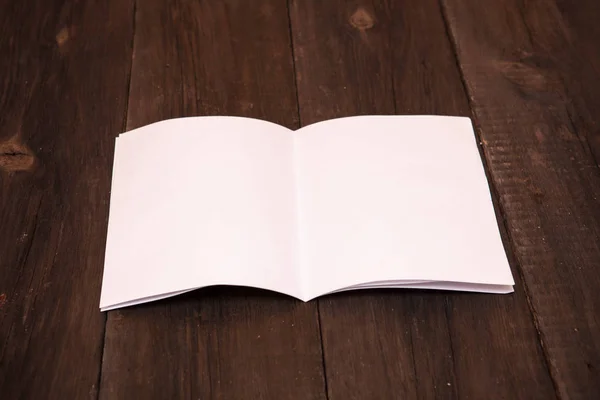 booklet of blank sheets of paper on a wooden background