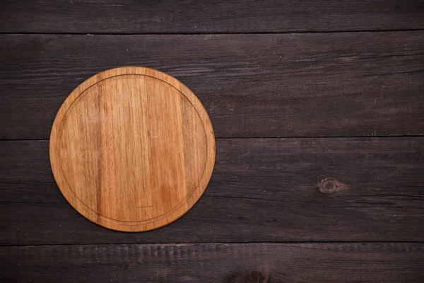 Yuvarlak ahşap kesme tahtası ahşap arka plan üzerinde