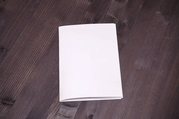 Sheet of paper folded in half on a wooden background — Stock Photo, Image