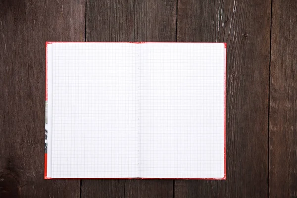 Öppna anteckningsboken i en bur på en trä bakgrund — Stockfoto