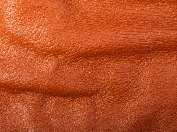 Orange leather in folds background — Stock Photo, Image