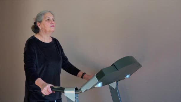 Fit femme âgée à la maison sur tapis roulant faire de l'exercice cardio . — Video
