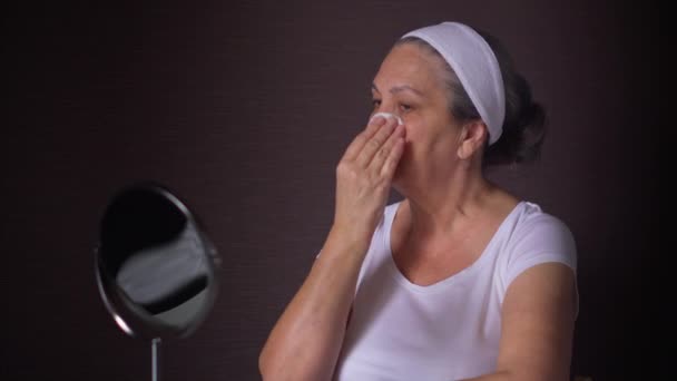 Dojrzała kobieta używa dysków kosmetycznych do czyszczenia twarzy po kąpieli — Wideo stockowe