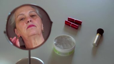 Senior woman bragging new jewelry accessories watching in mirror reflection.