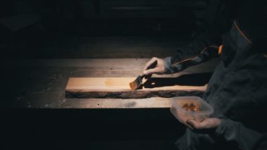 Üst görünüm, marangoz çalışma masası, fırça kullanan ahşap işçisi yağ tabakasına neden olur.