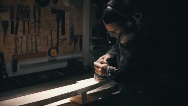 Homem polimento de madeira maciça, marceneiro trabalhando em máscara para a segurança — Vídeo de Stock