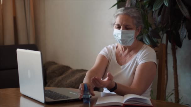 Коронавирус самоизоляции женщина с медицинской маской распыления антибактериального геля — стоковое видео