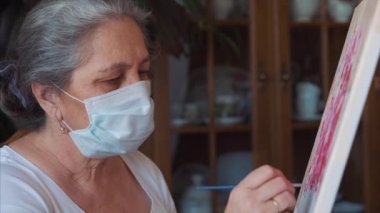 Coronavirus sanatçısı enfeksiyonu önlemek için evde temizlik maskesi takıyor.