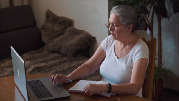 Coronavirus. Aged woman take notes at home. Woman in quarantine for coronavirus — Stock Video