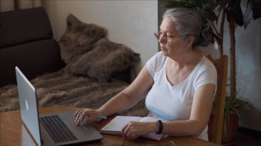 Coronavirus. Yaşlı bir kadın evde not alır. Coronavirüs yüzünden karantinada olan bir kadın.