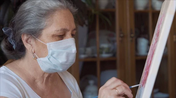 Coronavirus sanatçısı enfeksiyonu önlemek için evde temizlik maskesi takıyor.