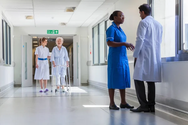 Enfermera ayudando a anciana anciana paciente en el corredor del hospital wi Imagen De Stock