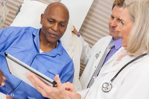 Paciente Africano Americano Sênior em Cama de Hospital com Médicos Imagem De Stock