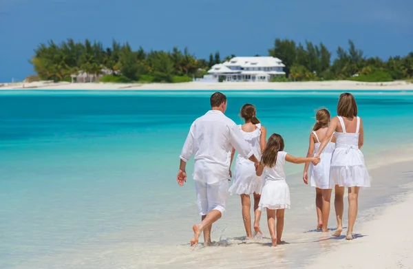 Happy Caucasian family in white walking on beach Royalty Free Stock Photos