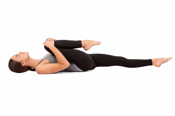 Beyaz arka planda güzel bir kız bacak esnetme egzersizi yapıyor. Yoga. Tabaklar. Sağlıklı yaşam tarzı kavramı..