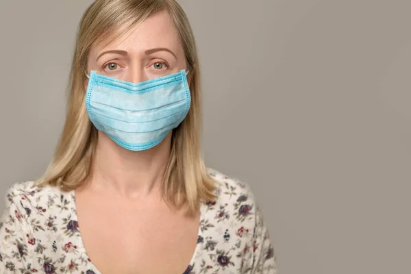 Closeup with a beautiful woman face wearing surgical mask — Stock Photo, Image