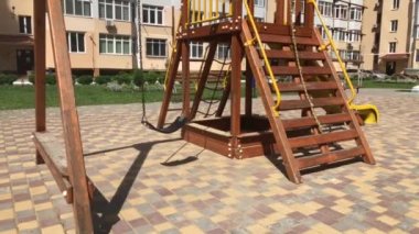Çocuklar boş salıncak yüksek bir binanın bahçesinde