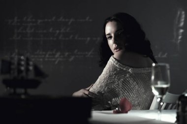 bağsız kıl genç ve güzel bir kızla sıradışı arka planda masada oturuyor. Tek renkli